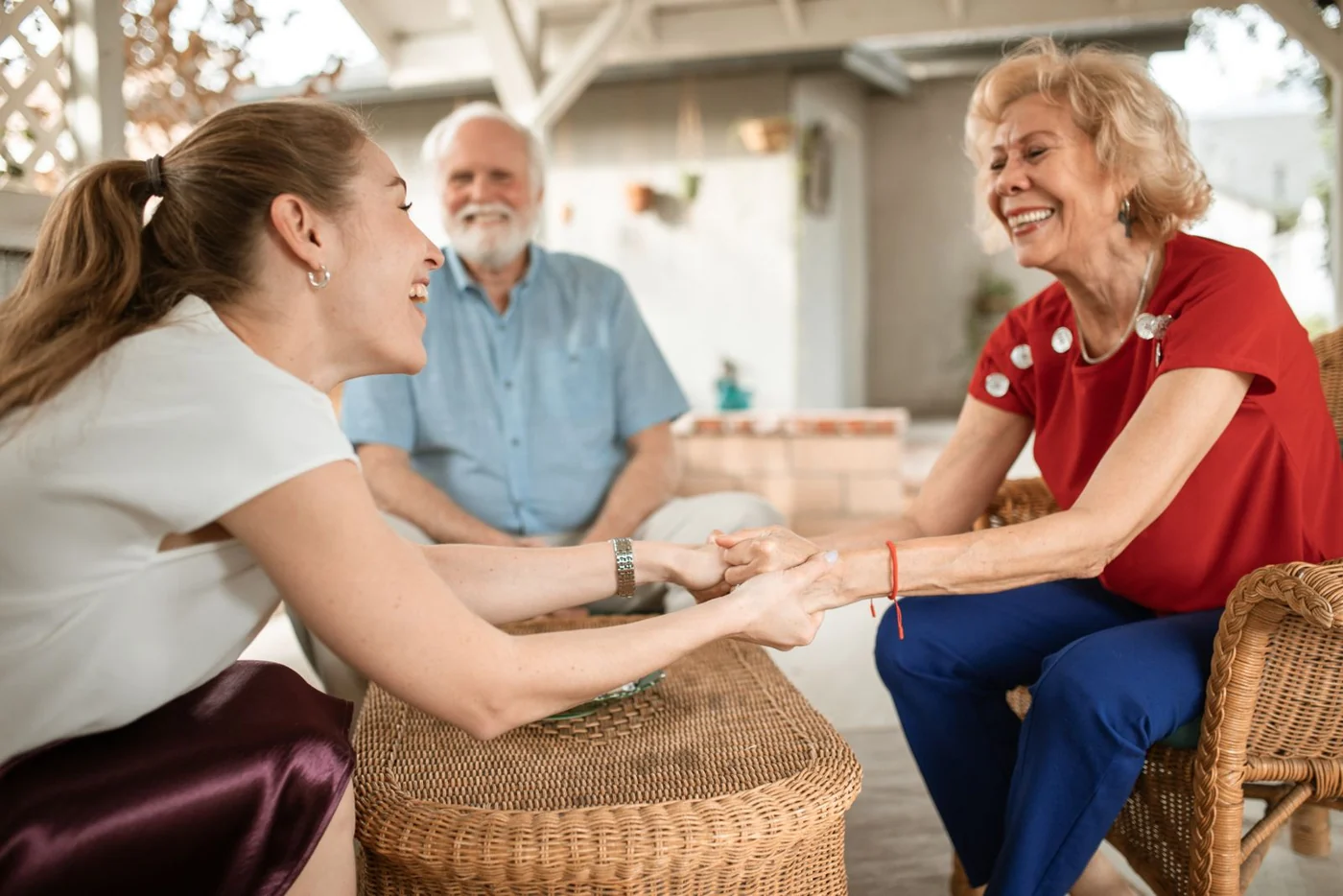 An older couple and a younger woman enjoying a conversation outside