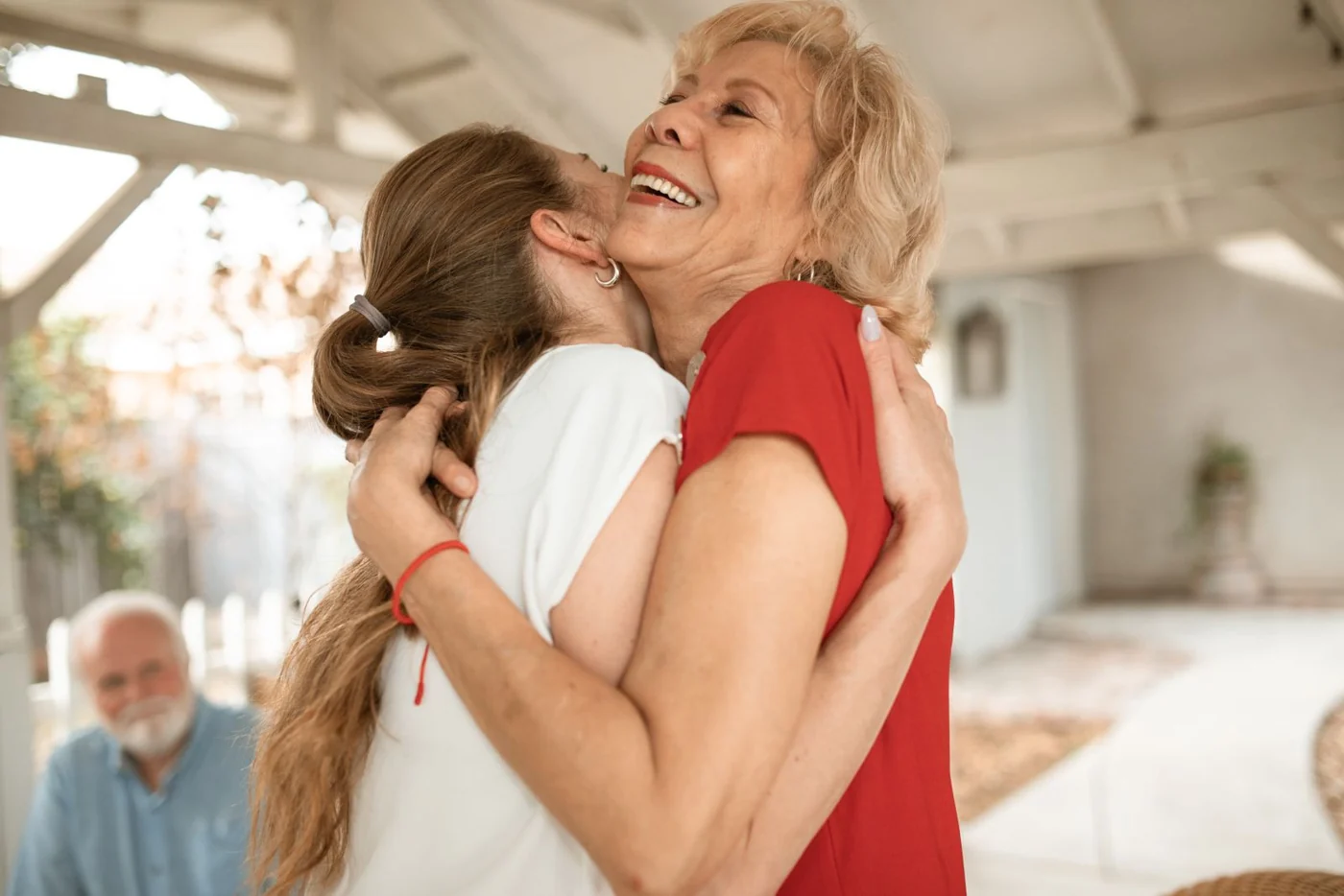 An older woman embracing a younger woman outdoors