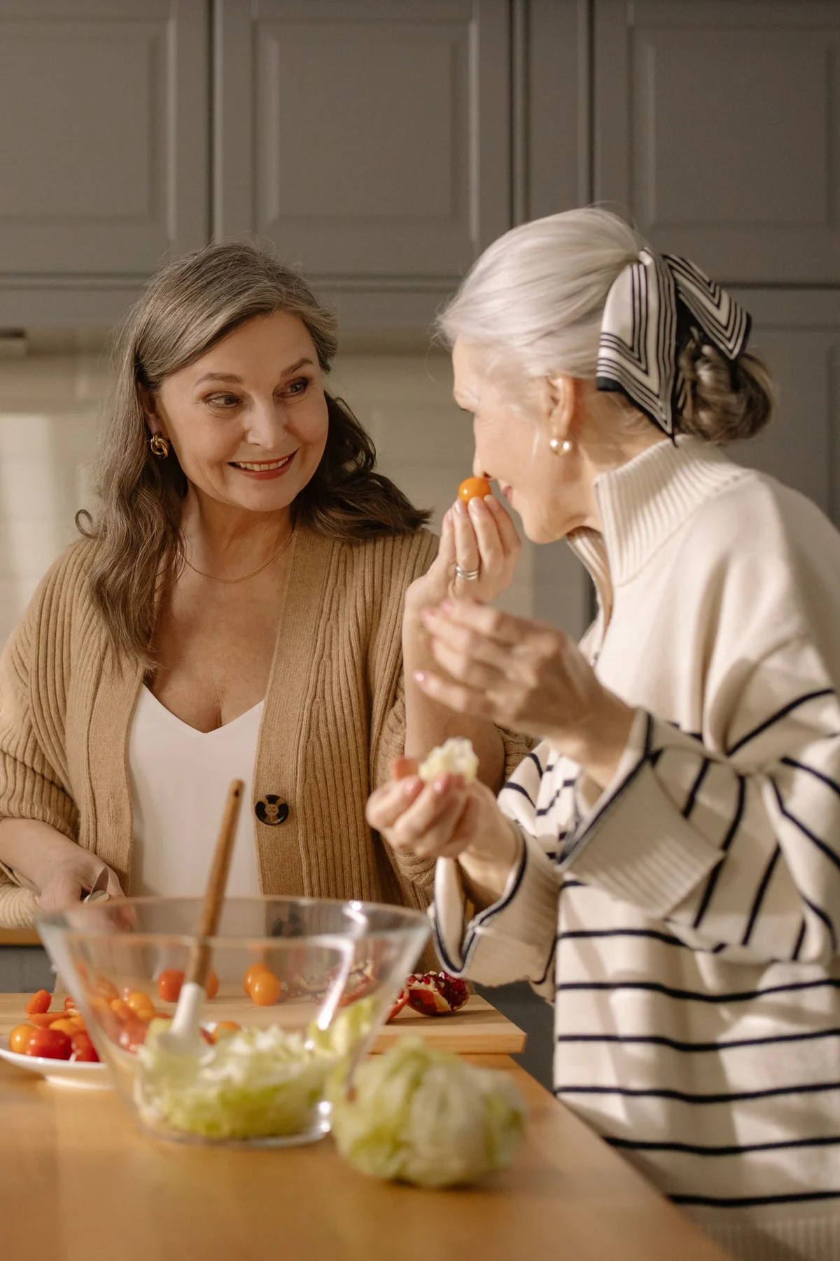 Two older women preparing a salad together