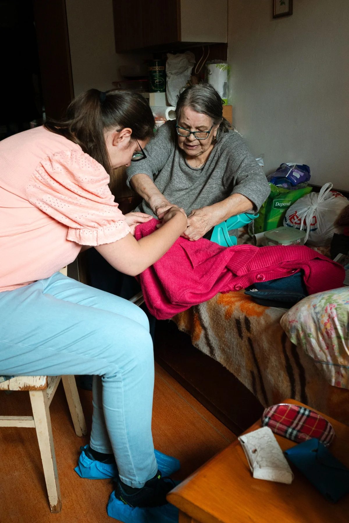 An older woman and a companion working on a sewing activity