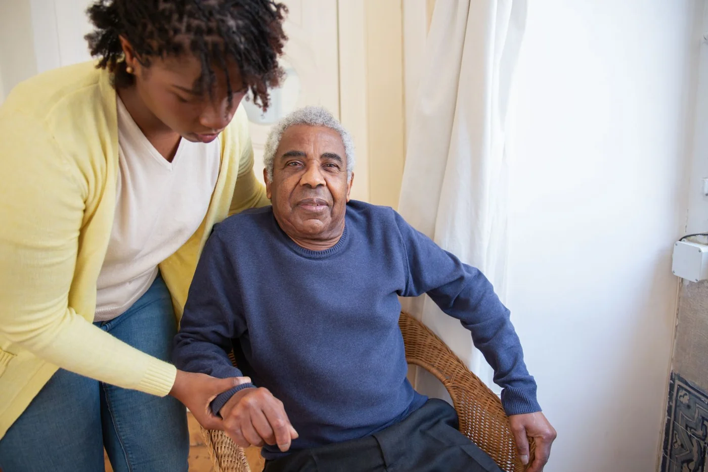 A younger woman sitting beside an older man at home